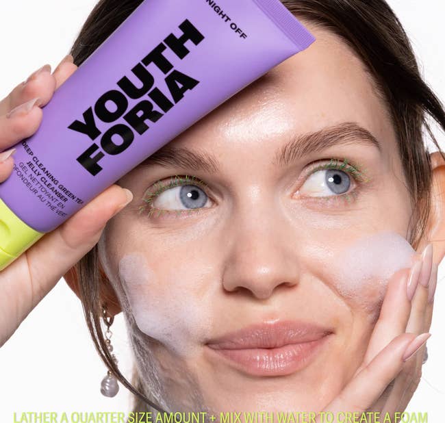 model washing face and holding cleanser