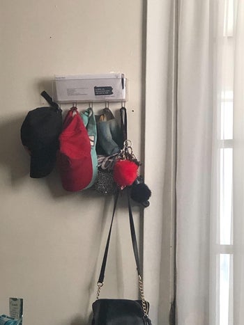 Reviewer's clear mail organizer holding hats and a purse