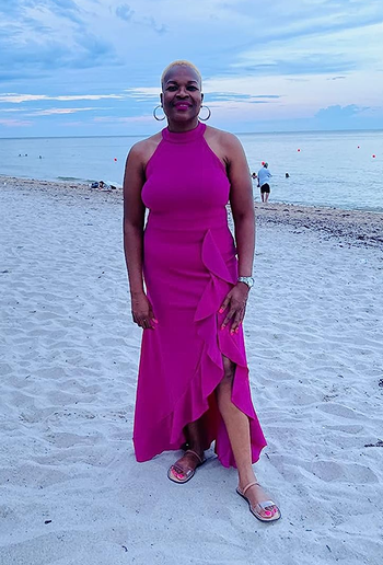 reviewer in the magenta long dress on a beach