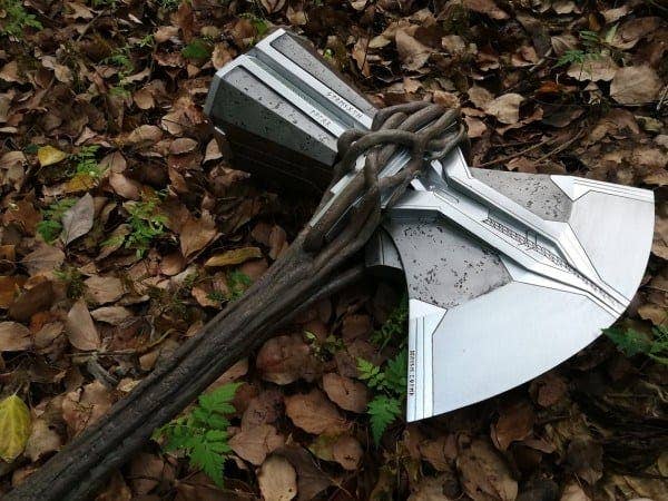 Replica of Thor's hammer, Mjolnir, with chain, on forest floor strewn with leaves