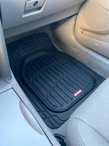 reviewer's black car mat in the front passenger seat