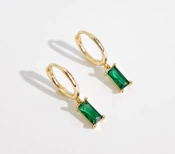 gold-plated huggie hoops with emerald charms