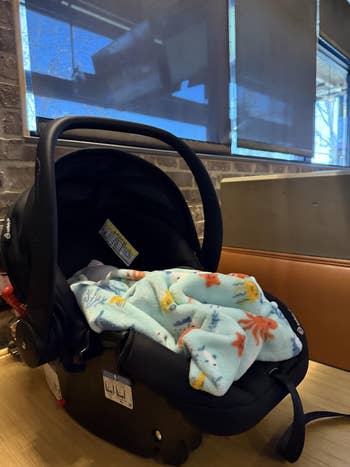 Baby car   spot   connected  a array  with a bluish  patterned broad  covering it. Indoor mounting  with brushed  lighting
