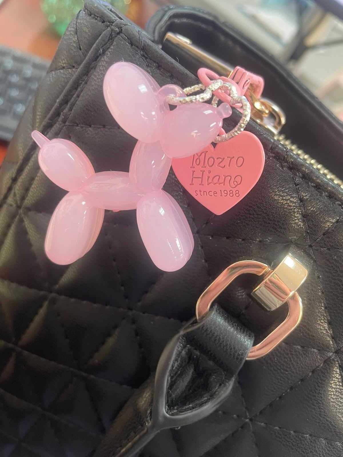 Quilted achromatic  handbag with a pinkish  balloon canine  keychain and heart-shaped tag speechmaking  