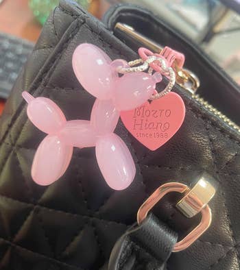 Quilted achromatic handbag with a pinkish balloon canine keychain and heart-shaped tag speechmaking