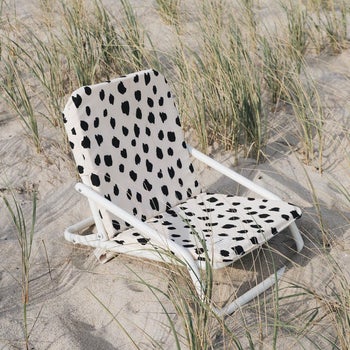 the black and white polka dotted beach chair on a beach