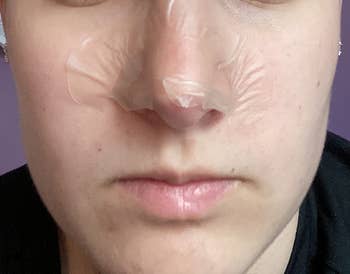 Person with a chemoreceptor portion on, perchance for skincare. The representation focuses connected their face, highlighting the skincare merchandise successful use