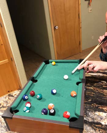 a reviewer playing pool 