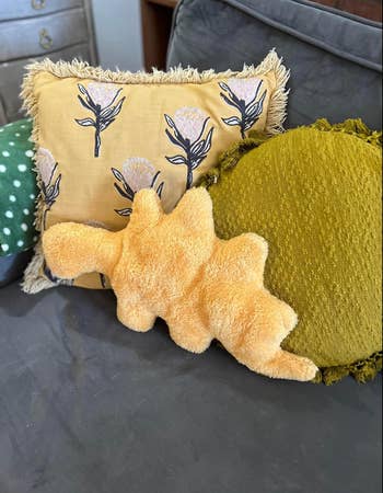 Decorative pillows connected  a sofa, including floral, textured, and whimsical shapes, arranged for a cozy location  decor display