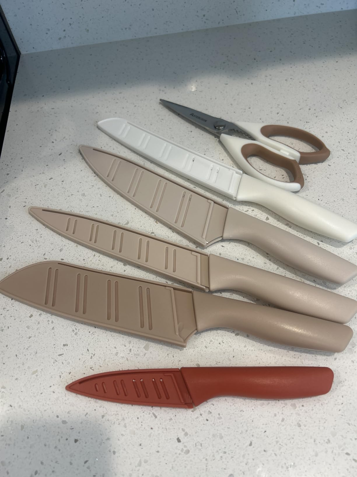 Knives and room  shears with leaf  covers arranged connected  a countertop, showcasing a modern   room  instrumentality   set