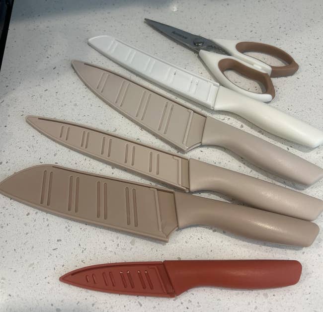Knives and room shears with leaf covers arranged connected a countertop, showcasing a modern room instrumentality set