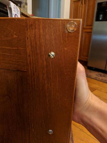reviewer showing clear round bumper on inside of cabinet door