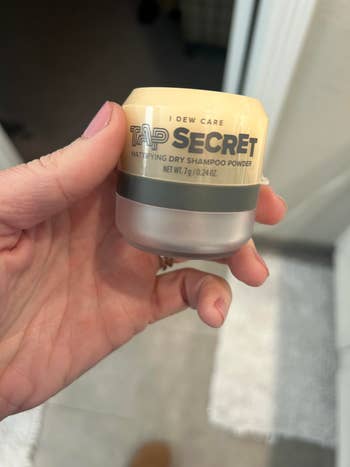 another reviewer holding a container of I Dew Care Tap Secret Dry Shampoo Powder