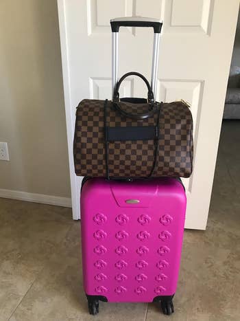 front view showing the handbag secured to the top of the suitcase