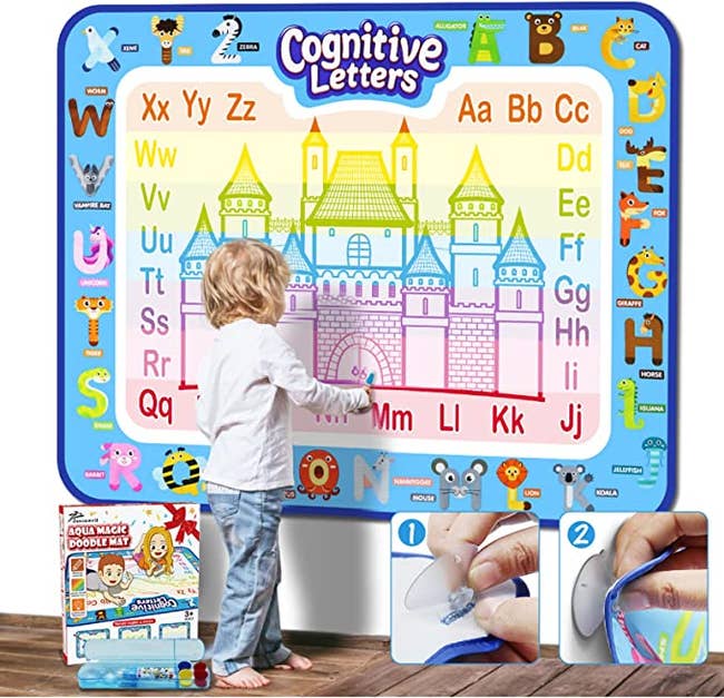 A child using a doodling mat that is 40 inches by 32 inches The mat is hanging on a wall and has the alphabet and animals around the frame and in the center of the mat is a rainbow castle