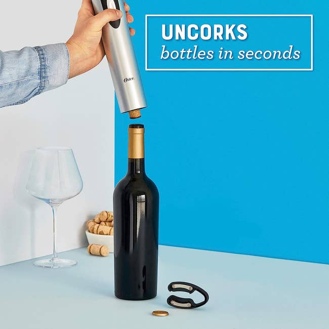 Electric wine opener being used on a bottle with the text 