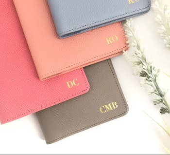 four different colored monogrammed leather passport holders