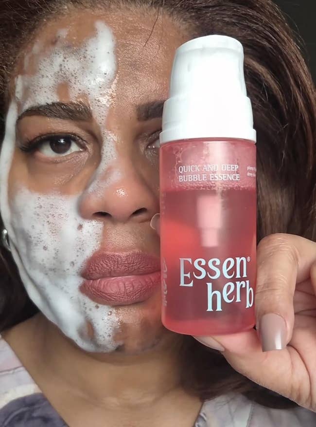 Person with foamy facial cleanser holds a vessel  labeled 