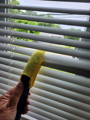 reviewer using duster on blinds
