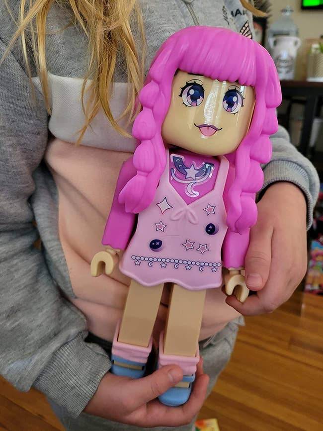 A child holding an Ava Star doll