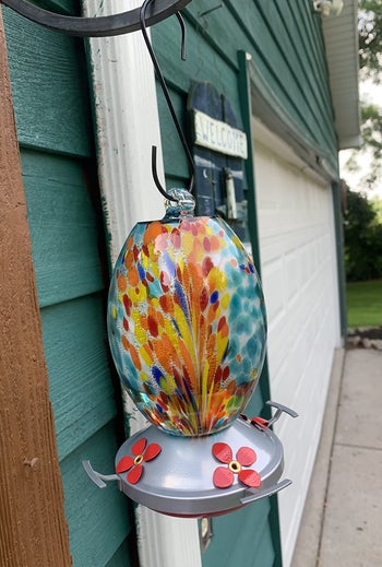 reviewer photo of hummingbird feeder hung up by front door