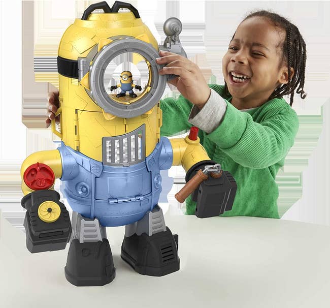 a child playing with the minion robot