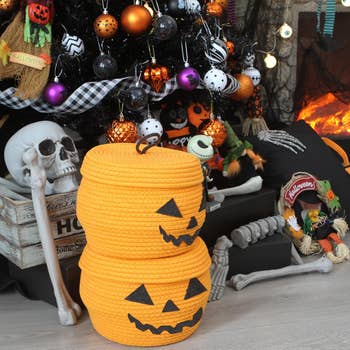 Halloween-themed buying  setup with orangish  pumpkin baskets, skeleton bones, and festive decor placed astir   a achromatic  Christmas histrion   adorned with Halloween ornaments