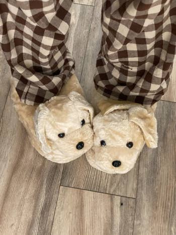 reviewer wearing the Golden Retriever slippers with PJ pants