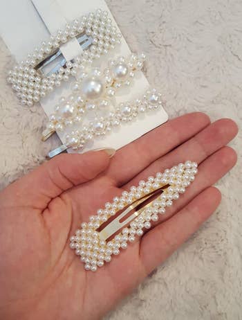 reviewer holding one of the pearly hair clips