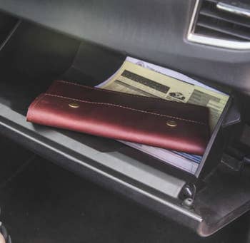 The burgundy pouch inside a glove compartment