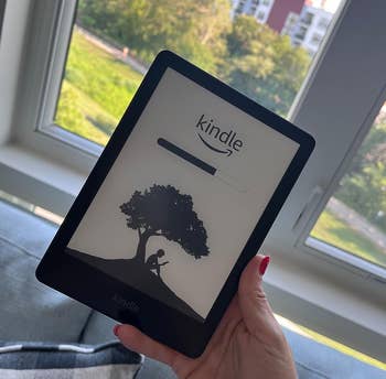 Another reviewer holding their Kindle 