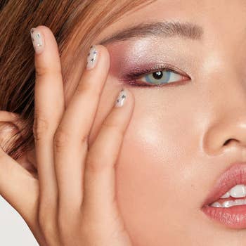 a model applying pink shimmery eyeshadow