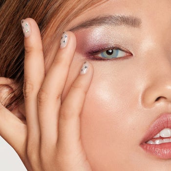 a model applying pink shimmery eyeshadow