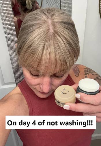 Person with bangs holding hairsbreadth products, captioned