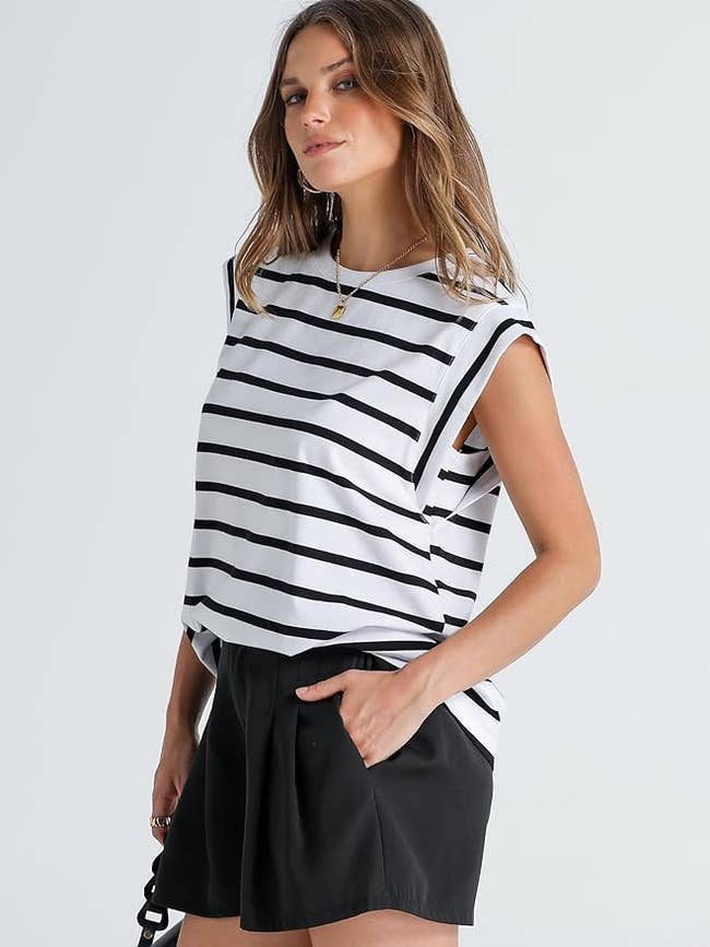 Model in a striped sleeveless top and black shorts, showcasing a casual outfit
