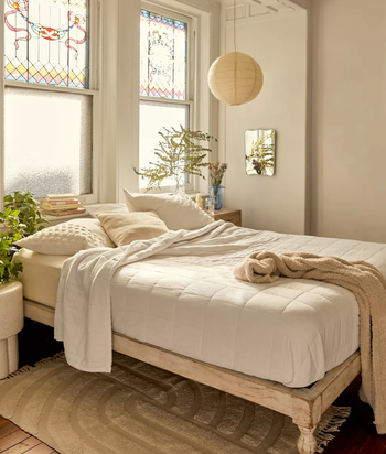 lifestyle image of bohemian wooden bed in bedroom