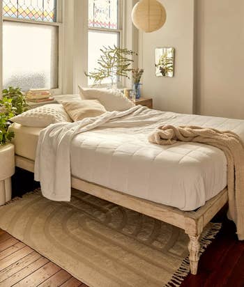 lifestyle image of bohemian wooden bed in bedroom