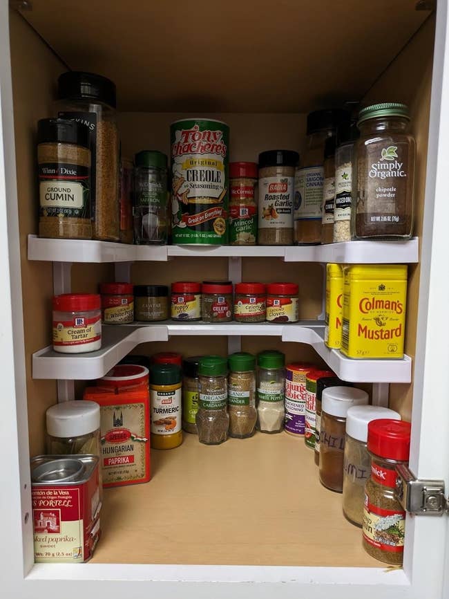 pantry shelf organized using spice rack to house a variety of spice jars and containers
