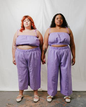 Two models wearing matching lavender tube tops and linen pants