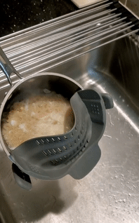 a gif of a a clip on strainer in use
