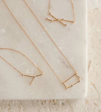 three gold constellation necklaces