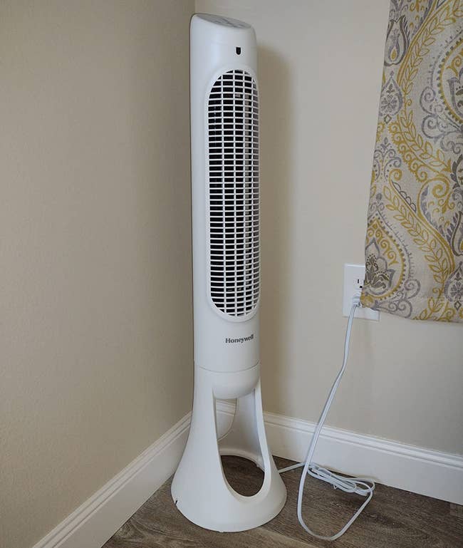 reviewer photo of the white fan in the corner of a room