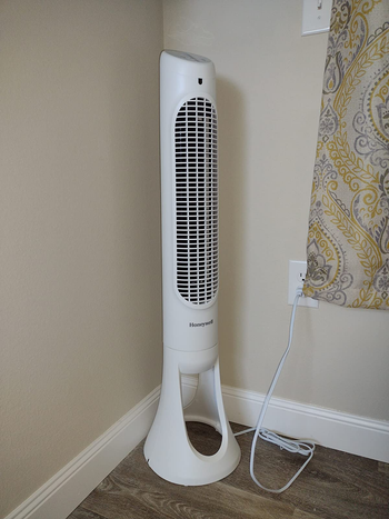 reviewer photo of the white fan in the corner of a room