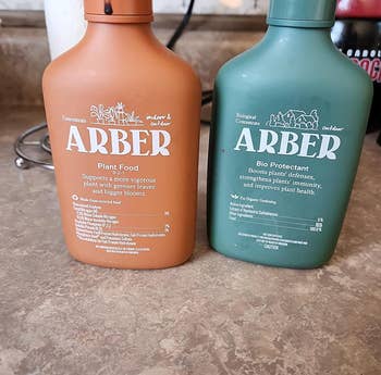Two ARBER plant care products on a counter, for growth support and protection