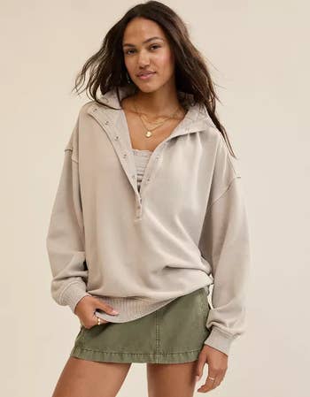 model successful  a casual oversized hoodie with a layered lace apical  and a abbreviated  skirt, posing confidently