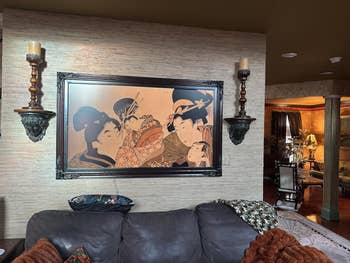 Framed accepted   Japanese artwork hangs supra  a sofa successful  a well-decorated surviving  country   with ornate sconces