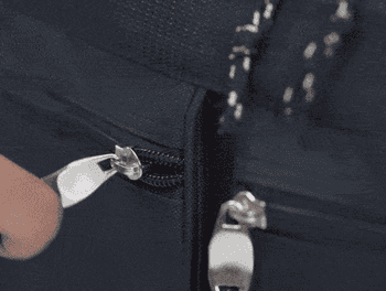 gif showing someone placing things into the duffel bag's zippered compartments