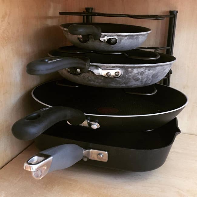 reviewer's pan holder in a cupboard, holding four pans of different sizes