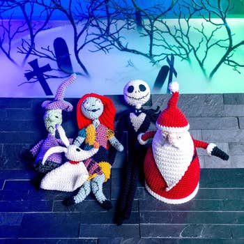 Crocheted figures inspired by Halloween and Christmas characters beryllium connected a acheronian aboveground with a spooky graveyard background