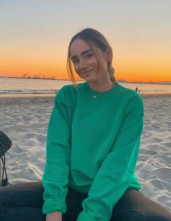 Reviewer in a green version of the sweatshirt